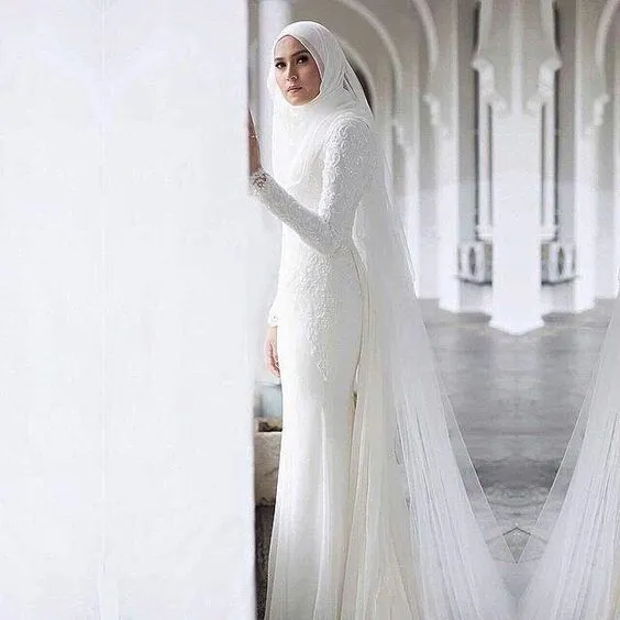 16 Inspirasi Gaun Pernikahan Putih Berhijab. Tertutup dan Tak Berlebihan Menonjolkan Lekuk Tubuh 25
