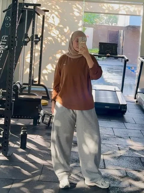 7 Outfit Gym Wanita Hijab yang Modis, Sopan, dan Nyaman 12 long sleeve sports top dan wide leg training pants